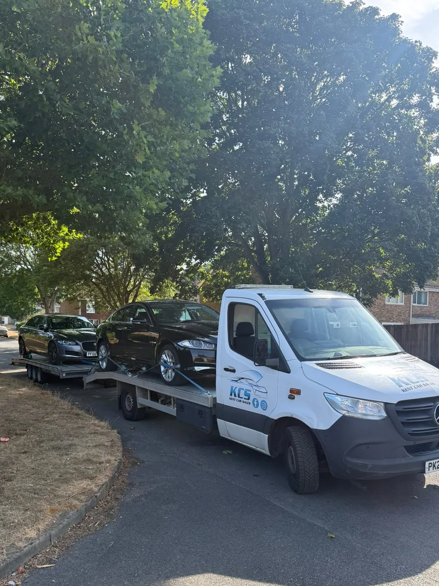 KCS Recovery transporter and trailer carrying two black Jaguar saloons on a Kent street